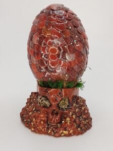 Handcrafted dragon egg in crimson red with skull stand